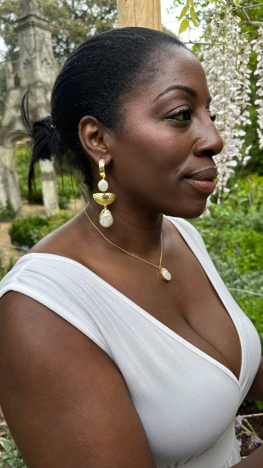 Woman wearing gold earrings and necklace outdoors